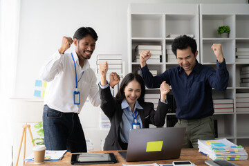 Team Success Celebration: Diverse business colleagues joyfully celebrate a win at their office, laptop, achievement, success 