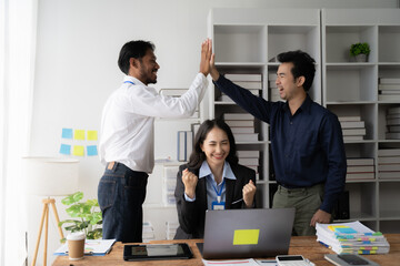 High Five Success: A diverse team celebrates a win with a celebratory high-five.  The image captures the energy and excitement of a collaborative workplace.