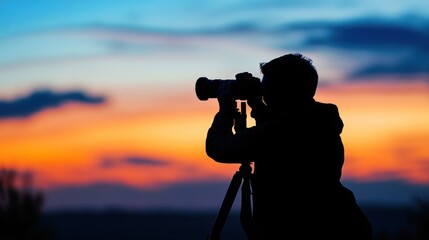 Obraz premium A silhouette of a person photographing a colorful sunset with a camera on a tripod.