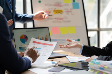 Strategic Business Meeting:  A diverse team collaborates around a table, reviewing data and...