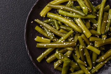 Steamed green beans on a plate with olive oil, sesame seeds