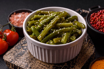 Steamed green beans on a plate with olive oil, sesame seeds