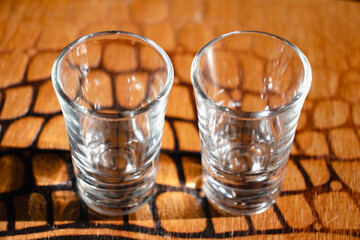 Two shot glasses on wooden background. Empty tequila shot glass. Alcohol equipment idea concept. Top view, above. Horizontal photo. No people, nobody. 