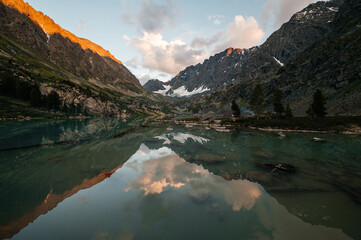 Kuyguk mountain lake in Altai in the light of a beautiful sunset sky