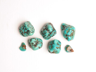 Several turquoise healing stones on a white studio background