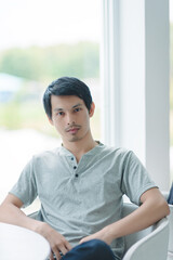 Young Man Sitting Near Window in Modern Indoor Setting