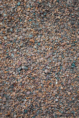 Stony beach on a sunny day. Background of different pebbles from above on the beach