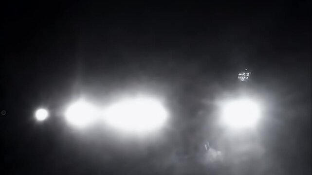 Rapid flashes of white light simulating paparazzi cameras, lighting up a dark background in chaotic patterns