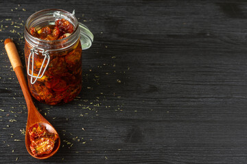 Jar of sun-dried tomatoes on a wooden table
