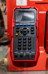 Compact portable battery analyzer in red.