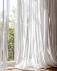 Bright, airy room with sheer white curtains flowing gently by a sunny window.