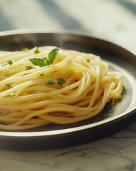 A plate of steaming spaghetti garnished with fresh basil, showcasing a delicious Italian dish.