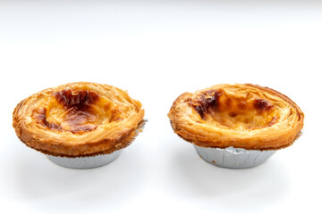 Two baked egg tarts isolated on white.