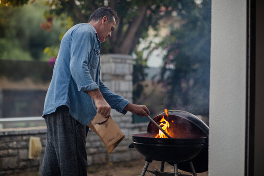 Man preparing fire in a grill for barbecue