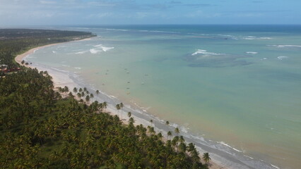 Vue aérienne panoramique d’une plage en bord de mer avec eau turquoise et bateau
