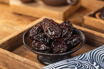 There are dried plums and dried sweet fruit preserves on the table