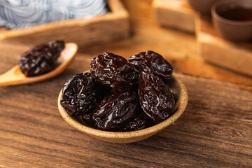 There are dried plums and dried sweet fruit preserves on the table