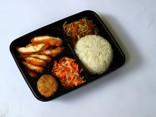 Katsu chicken, rice, noodles, mashed potatoes, vegetable salad, and fritter served on bento box meal isolated white, copy space. Suitable for students and busy worker, home business opprtunity