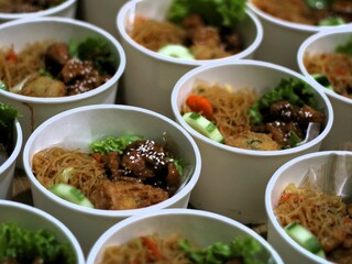 Amounts of teriyaki glazed chicken rice bowl with vegetables, noodle, sliced cucumber and wortel and mashed potatoes on black background. Balanced nutritious food