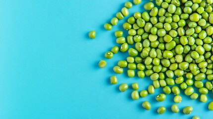 Raw mung beans isolated on a soft pastel blue background, showcasing their vibrant green hue