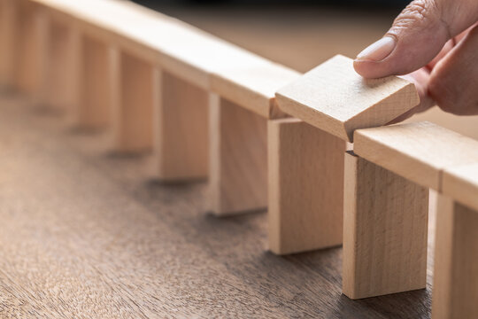 Closeup hand that building the wooden pieces as a bridge, and going to fill the gap with the last piece, gap and disconnect problem, solution to solve it, build success