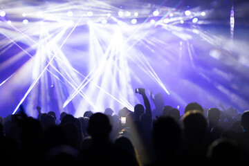 Crowd at concert and colorful stage lights.