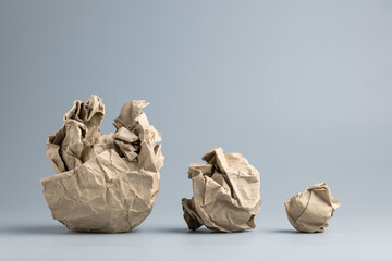 A row of crumpled paper balls reduced in size, close to fine the success idea, big problems become...