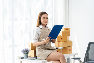 Smiling Woman reviewing Orders for Online Business