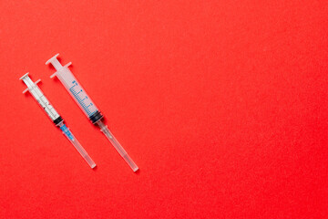 Top view of different syringes for injection on colorful background. Medical equipment concept with copy space