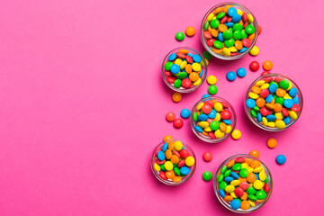 different colored round candy in bowl and jars. Top view of large variety sweets and candies with copy space