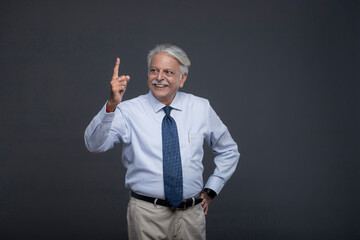 Smiling Senior Pointing Up One Finger