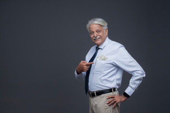 An Old Man While Standing Showing Notes In His Pocket