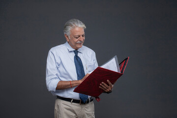 Handsome Old Businessman Checking The Financial Papers In File