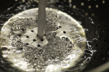 Close-Up of Running Water Splashing into Metallic Sink Drain