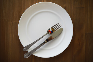 Health Concept Fork and Knife with Pills on White Plate Wooden Background