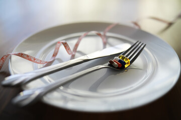 Diet Concept with Pills and Measuring Tape on Empty Plate
