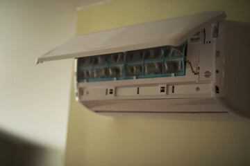 Close-Up of Wall-Mounted Air Conditioner with Open Cover in Home Interior