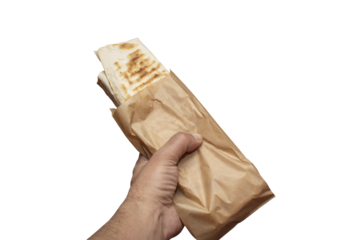 Hand holding Shawarma sandwich gyro - fresh roll of thin lavash (pita bread) filled with grilled meat isolated