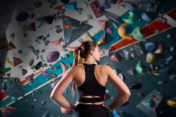 Climber athlete against steep wall in climbing gym