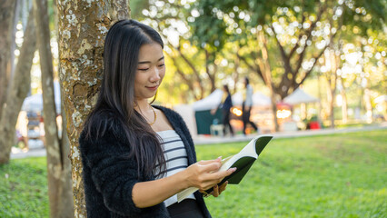 Happy girl reading a book in park, concept of Relaxation.