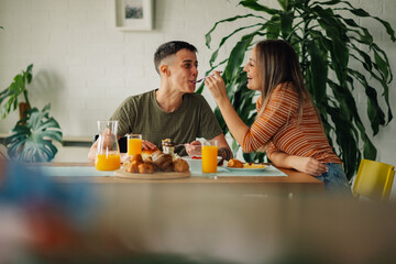 Lesbian couple sharing food and enjoying breakfast at home