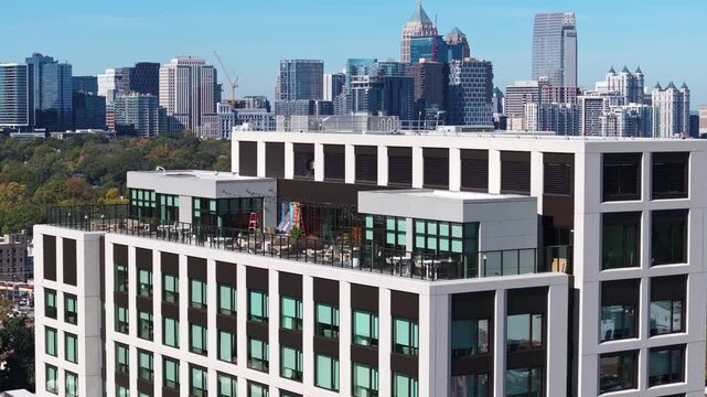Rooftop bar cafe with Midtown Atlanta commercial and residential skyline buildings and neighbourhood in background, Georgia, Drone shot