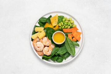 Shrimp salad with spinach, edamame beans, carrot, corn, mango on white background. Healthy food  concept