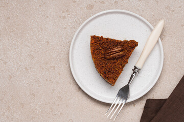 Slice of vegan carrot cake with pecans on white background with copy space