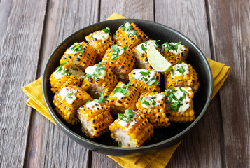Grilled corn with white sauce and herbs. BBQ. Picnic. Vegetarian food. Diet.