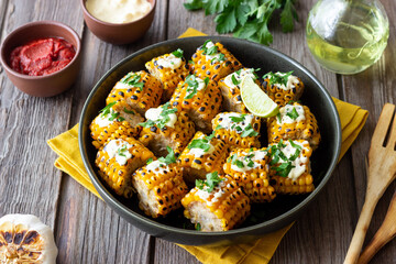 Grilled corn with white sauce and herbs. BBQ. Picnic. Vegetarian food. Diet.