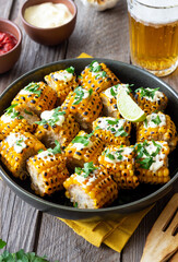 Grilled corn with white sauce and herbs. BBQ. Picnic. Vegetarian food. Diet.