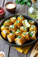Grilled corn with white sauce and herbs. BBQ. Picnic. Vegetarian food. Diet.