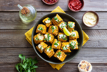 Grilled corn with white sauce and herbs. BBQ. Picnic. Vegetarian food. Diet.