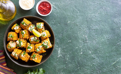 Grilled corn with white sauce and herbs. BBQ. Picnic. Vegetarian food. Diet.